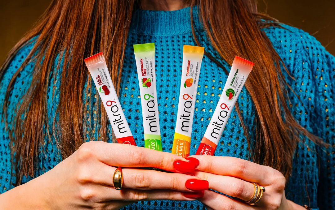 Mitra9 mitragynine drink mix stick packs in multiple flavors including black cherry, raspberry lime, tangerine, and watermelon held in hand – functional drink mix for energy, mood, and non alcoholic beverage alternative