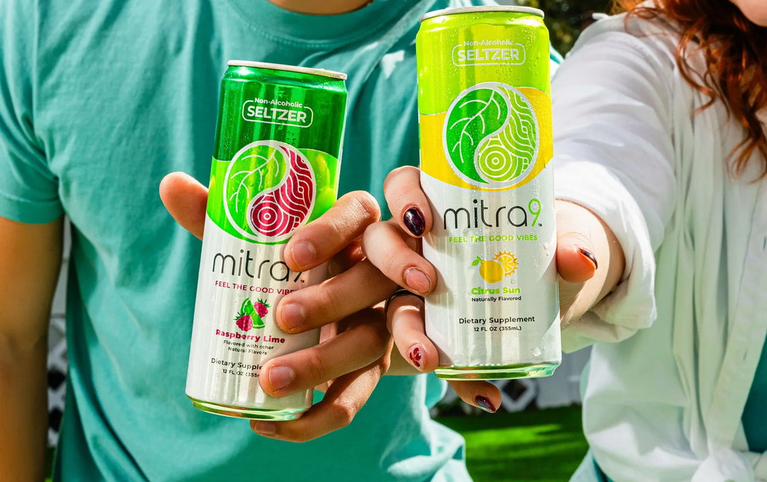 Mitra9 functional drink seltzer cans Raspberry Lime and Citrus Sun flavors held outdoors refreshing kava soda and kratom seltzer alternative beverage