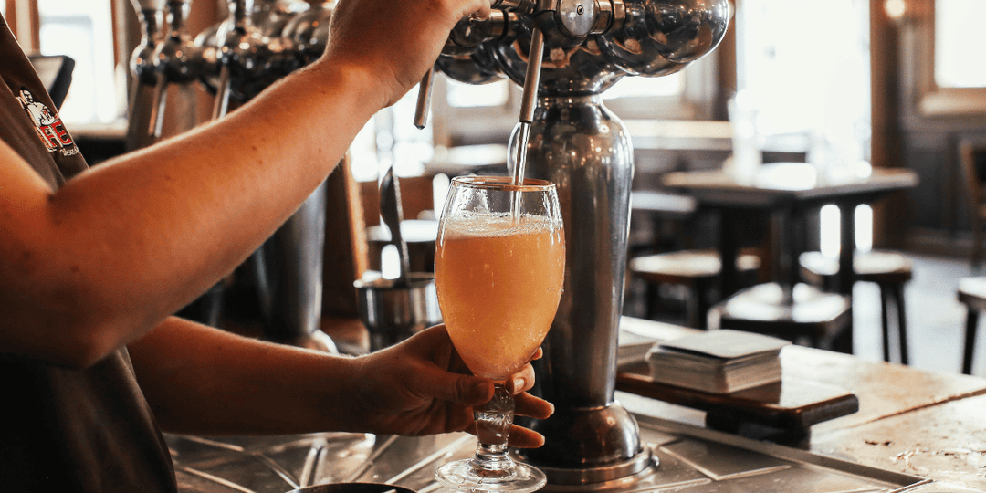 Non-alcoholic beer-style drink being poured from a tap into a glass at a bar, highlighting alcohol-free alternatives and the growing trend of zero-proof social drinking