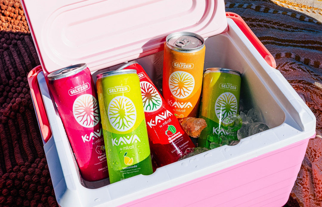 Colorful Kava by Mitra9 functional drink seltzers in a pink cooler filled with ice, featuring lemonade, strawberry watermelon, paradise lychee, and tropical flavors for a refreshing non-alcoholic kava soda experience