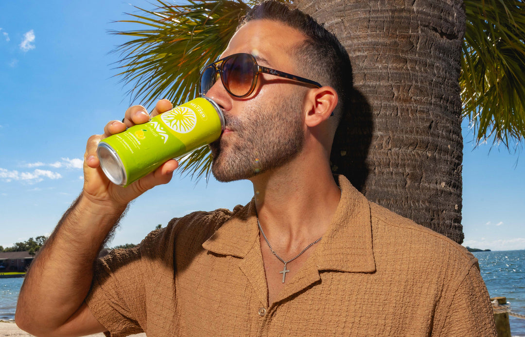 Man Wearing Sunglasses Drinking Kava Seltzer at Beach