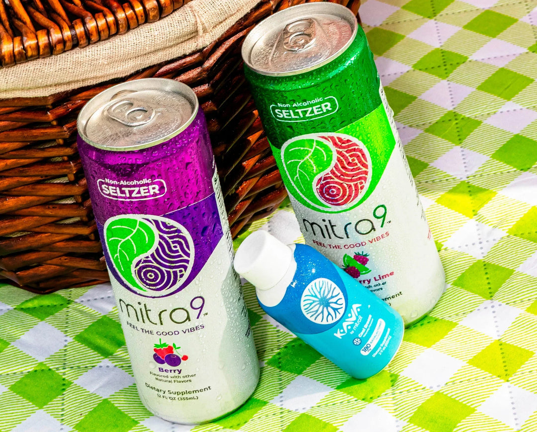 Mitra9 functional seltzer drinks in berry and raspberry lime flavors with kava shot bottle on picnic table – non alcoholic seltzer and mitragynine drink mix for relaxation and social occasions
