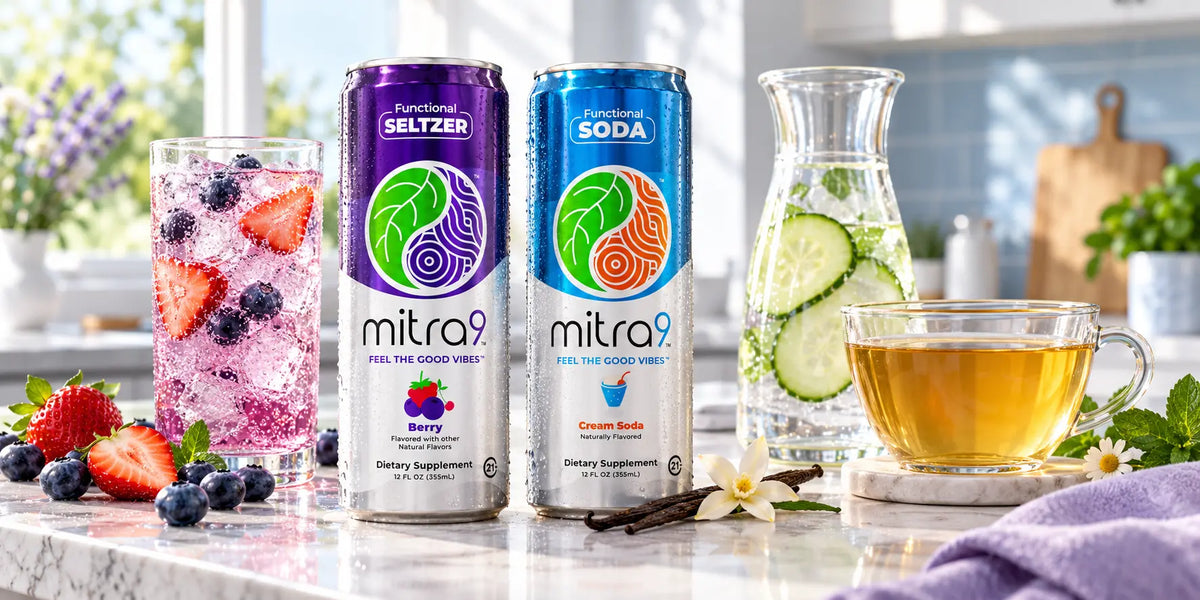 Mitra9 Berry seltzer and Cream Soda cans beside an iced berry drink, cucumber water, and herbal tea in a bright kitchen.