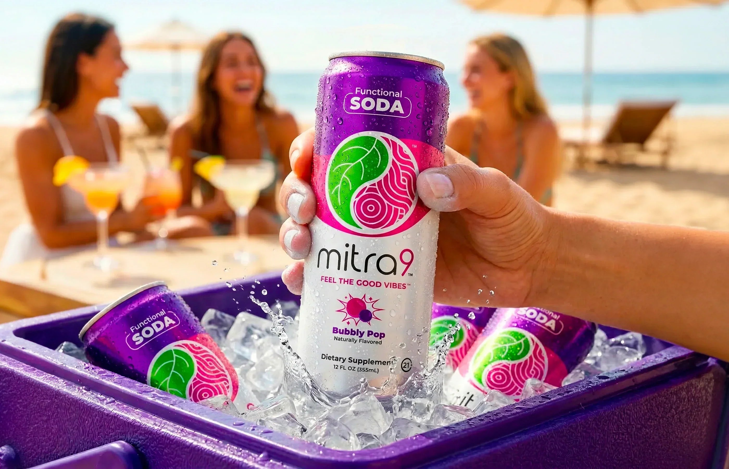 Hand holding Mitra9 Bubbly Pop functional soda can in an ice-filled cooler at the beach with friends in the background, showcasing a refreshing Mitragynine drink and alcohol alternative in a social summer setting